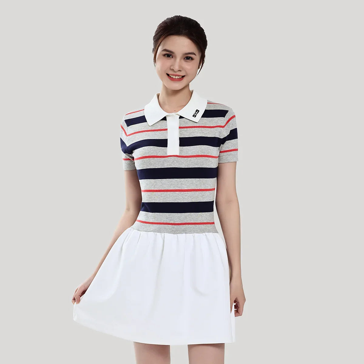 Woman wearing a striped dress with a white collar on a plain background