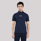 Man wearing a navy blue t-shirt with a logo on a light gray background