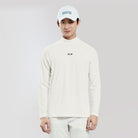 Person wearing a white long-sleeve shirt and cap with a logo on a plain background