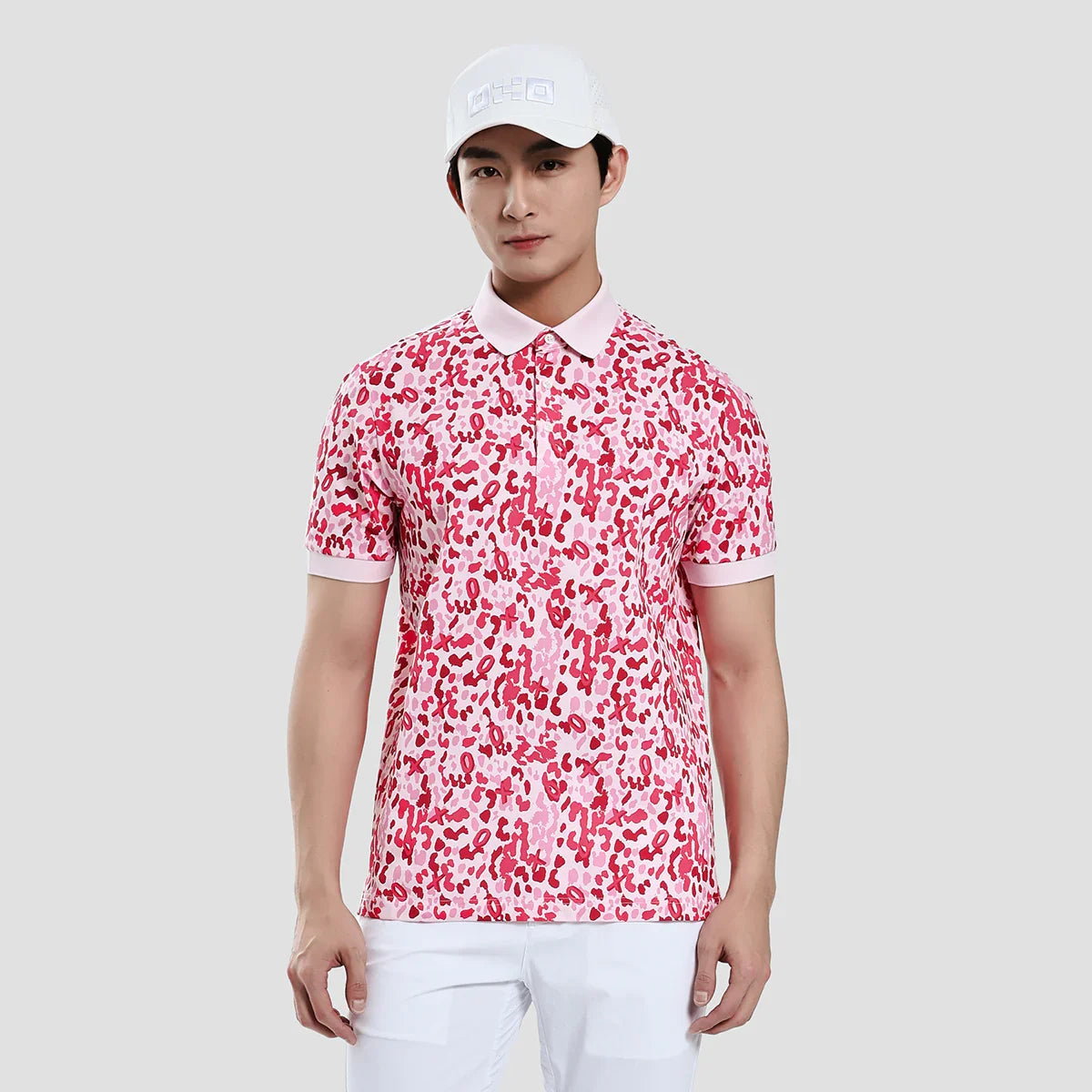 Person wearing a red and white patterned polo shirt with a white cap on a light gray background