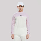 Person wearing a light purple and white long-sleeve shirt with a cap on a gray background