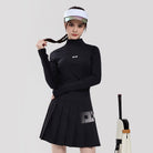 Woman wearing a black outfit with a visor and skirt, standing next to a tennis racket on a light gray background.