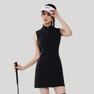 Woman in a black sleeveless dress holding a golf club against a light gray background