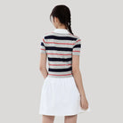 Woman wearing a striped shirt and white skirt on a plain background