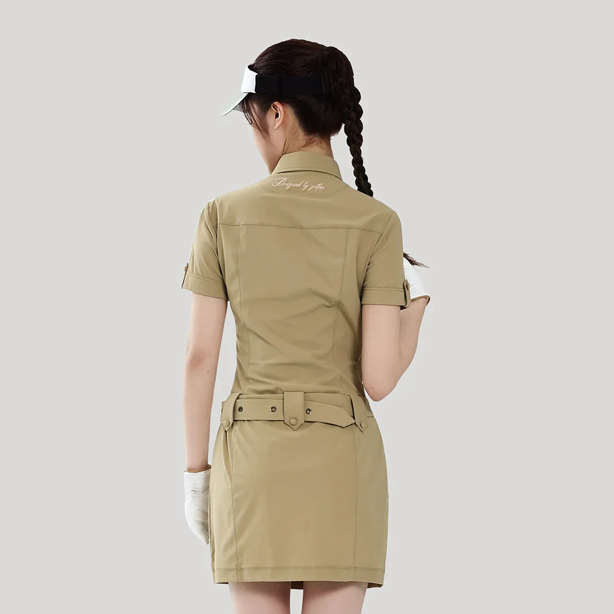 Woman wearing a beige dress with a white logo on a light gray background