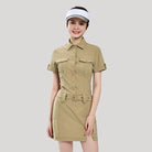 Woman wearing a beige safari-style dress with a belt on a light gray background