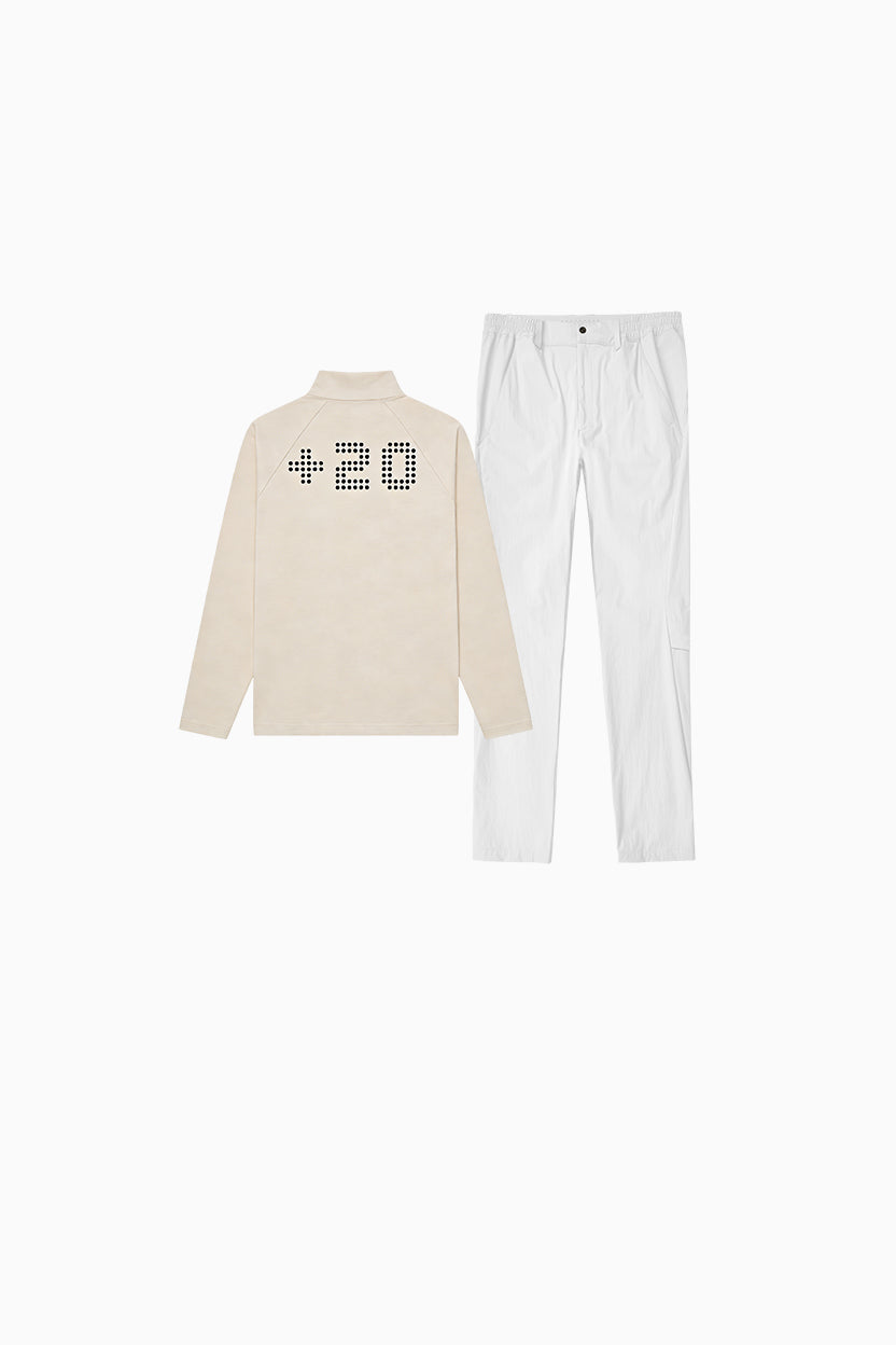 Beige long-sleeve shirt with text and white pants on a white background